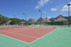 Outdoor tennis court surrounded by tropical hills and villas, part of luxury vacation rentals in St Barts.