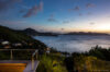 Sunset view over the Caribbean Sea from a St Barts villa terrace with lush hillside surroundings