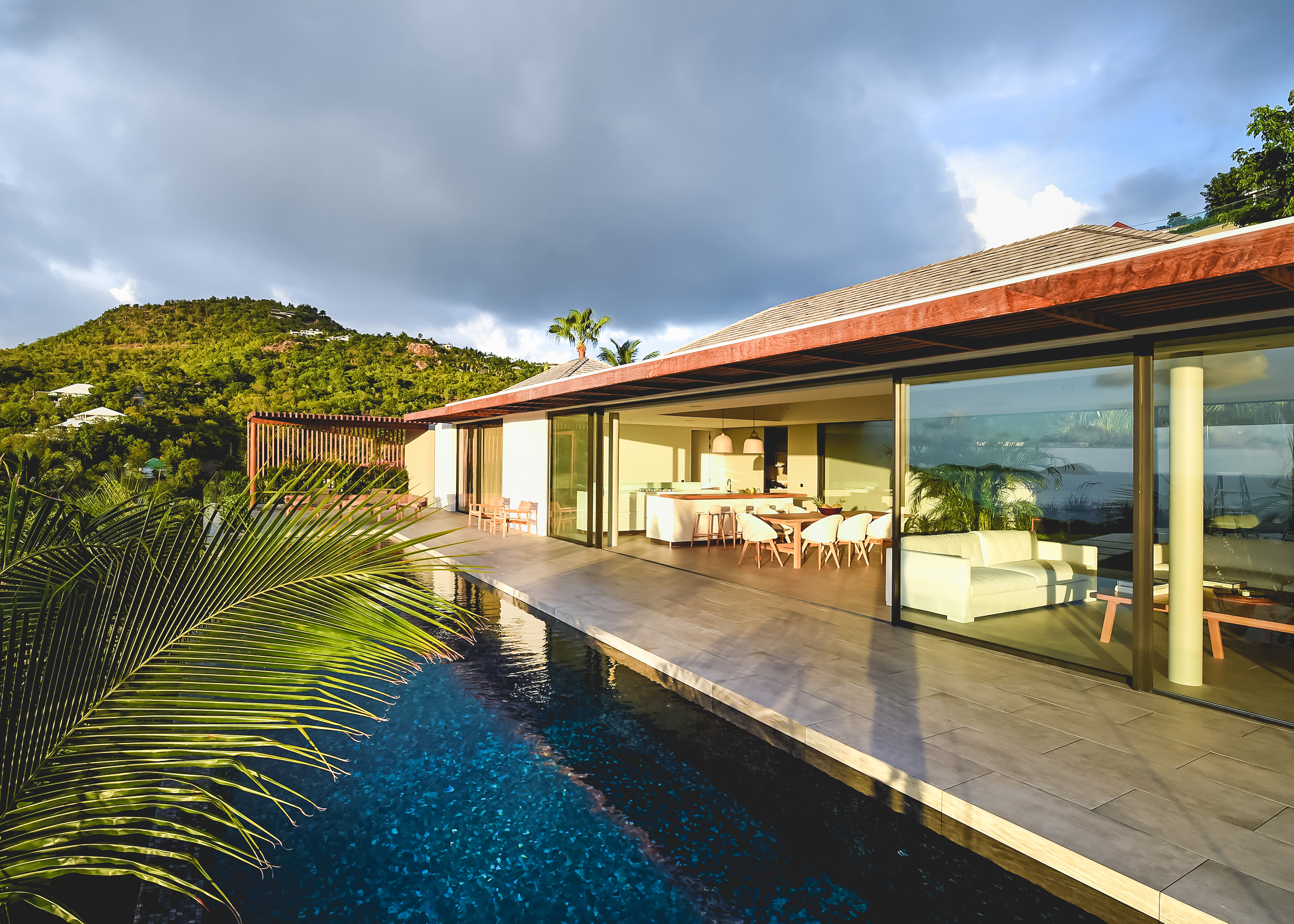 Contemporary St Barts villa with floor-to-ceiling glass, open living spaces, and poolside terrace overlooking the hills.