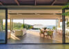 Open-air living and dining space in a St Barts villa with ocean views at sunset and modern island décor..