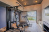 Private gym at a St Barts villa with treadmill, weight machine, and ocean view.