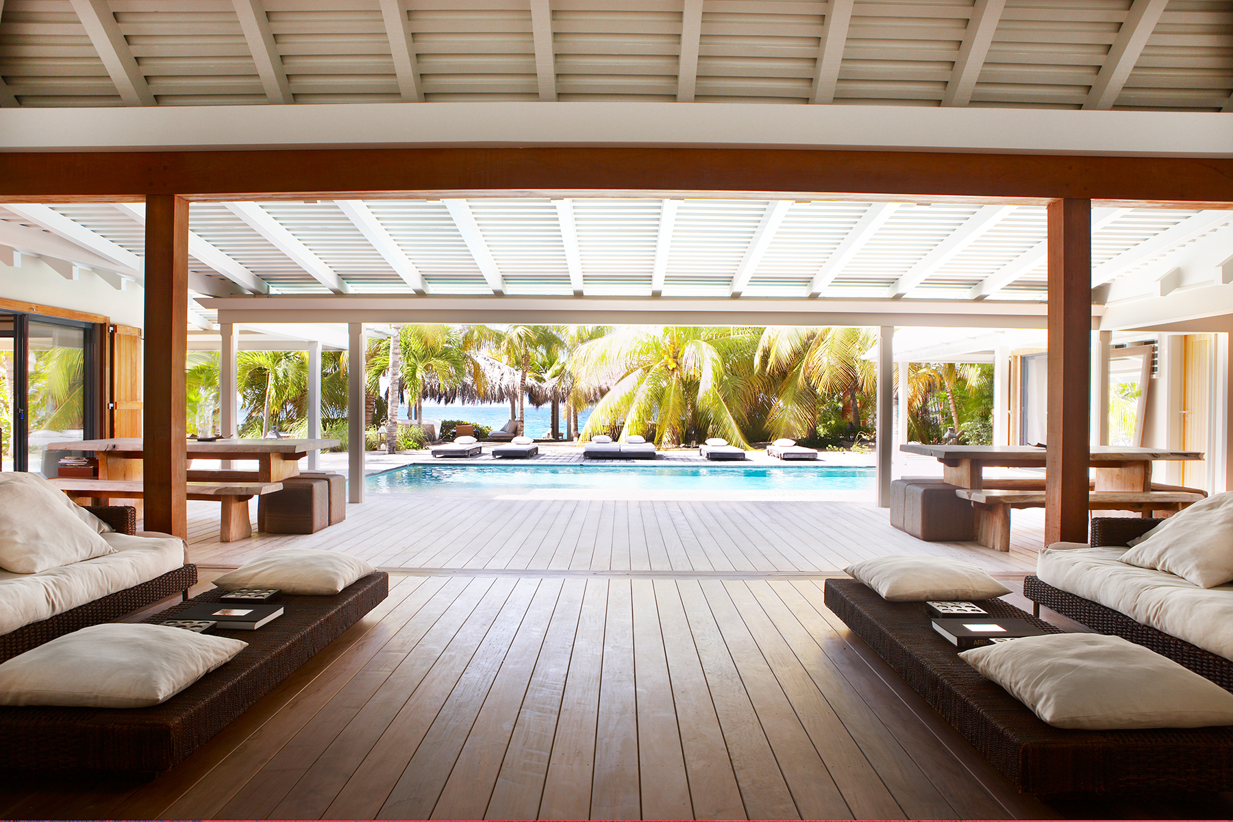 Covered terrace lounge with pool view and tropical gardens at a luxury villa in St Barts