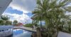 Terrace with swimming pool, palm trees, and ocean view at St Barthelemy villa rental