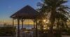 Gazebo with seating facing ocean sunset and palm trees at St Barthelemy villa rental