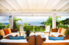 Shaded lounge of St Barts vacation rentals with colorful cushions and Caribbean Sea view