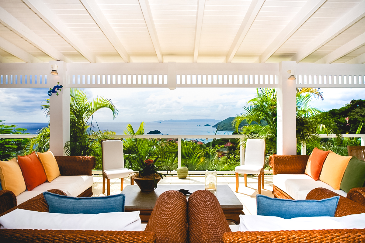 Shaded lounge of St Barts vacation rentals with colorful cushions and Caribbean Sea view