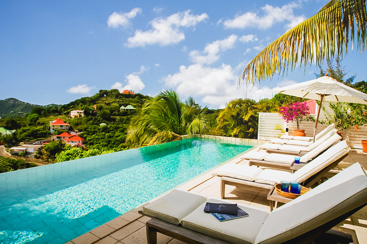 Infinity pool of St Barts villa hire with sun loungers and hillside views