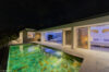 Illuminated villa pool at night with open living spaces and modern interiors in St Barts villa rental.