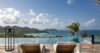 Two sun loungers facing an infinity pool and sweeping Caribbean Sea views at a luxury St Barts villa.
