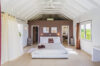 Primary bedroom in St Barts villa rental with vaulted ceiling and garden views