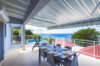Covered terrace with dining table, pool, and panoramic ocean view at St Barts villa rental