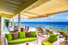 Shaded terrace of St Barts luxury rentals with green lounge seating and sea views