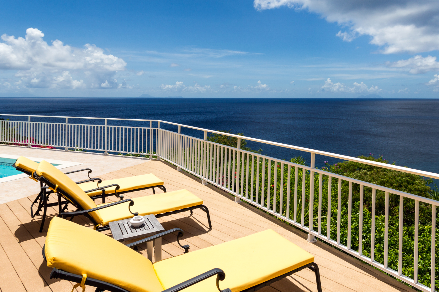 Sun deck of St Barts villa rentals with yellow loungers and Caribbean Sea views