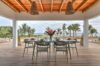 Covered dining terrace with tropical flower centerpiece and ocean views at a St Barts villa rental.