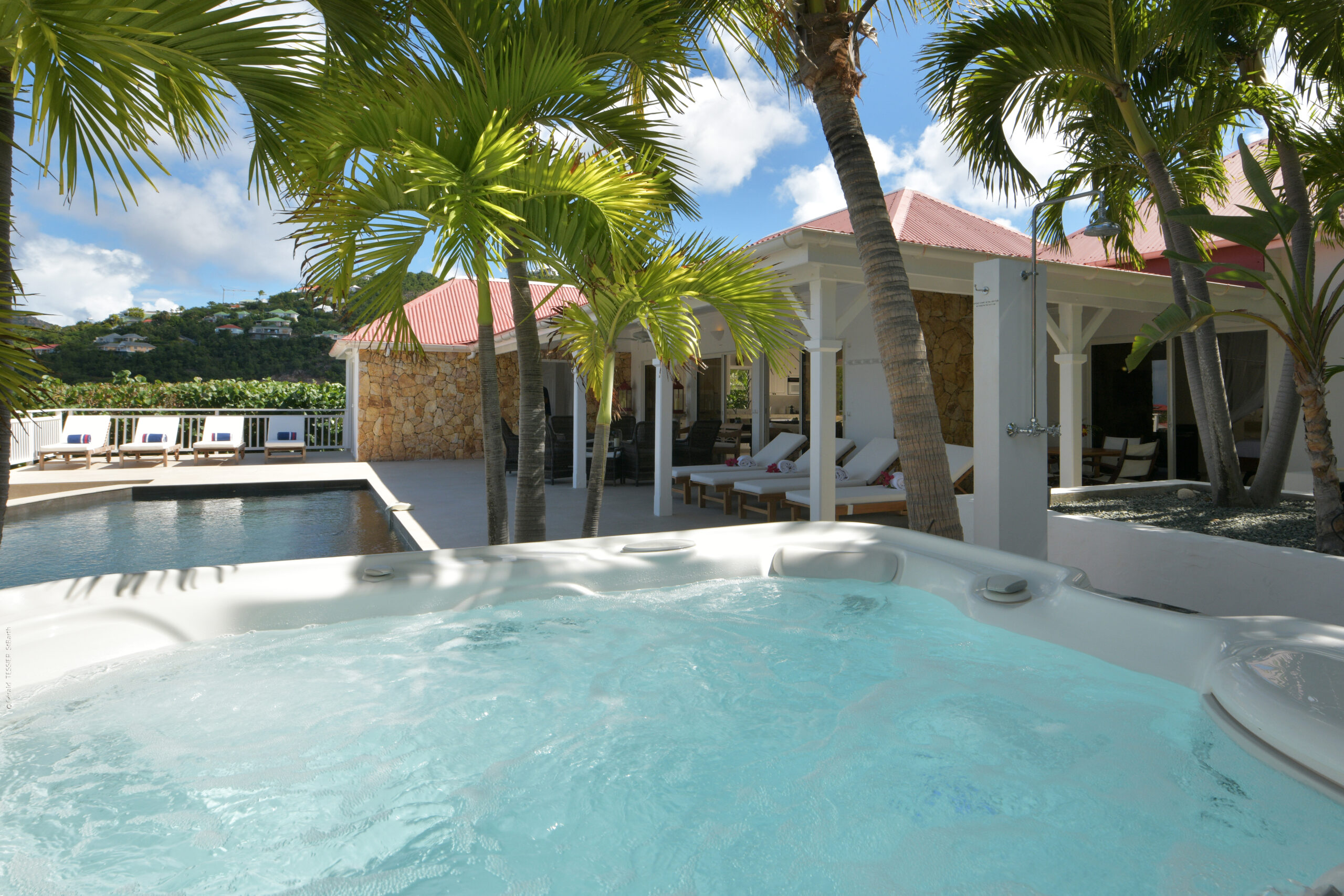 Luxury villa in St Barts with jacuzzi under palm trees and poolside terrace