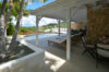 Shaded terrace with lounge chairs beside private pool and hillside views in St Barts villa rental
