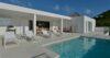Modern white villa with sun loungers by the poolside terrace in St Barts.