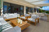 Shaded outdoor lounge with white cushioned seating and dining area at a luxury villa in St Barts.