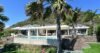 Modern villa with infinity pool and palm trees set against the hillside in St Barts.