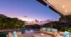 Terrace lounge of a St Barts villa with pool, turquoise cushions, and panoramic sunset views over the Caribbean Sea.