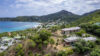 Aerial view of luxury villas in St Barts surrounded by lush hills, overlooking Lorient Bay and the Caribbean Sea.