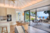 Bright modern kitchen and dining area opening to a covered terrace with pool and ocean views at a luxury St Barts villa rental.