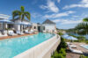 Expansive infinity pool with sun loungers and ocean views at a luxury villa in St Barths.