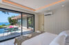 Bright bedroom in a St Barts villa with sliding doors opening to a private pool deck and sea view.