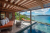 Shaded deck with daybeds and infinity pool overlooking turquoise waters in a luxury St Barts villa rental.