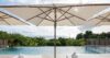 Infinity pool with sun umbrellas overlooking lush greenery and ocean horizon at luxury villas St Barts