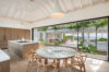 Open-plan kitchen and dining area at St Barts villa with wood accents, garden views, and seamless indoor-outdoor living