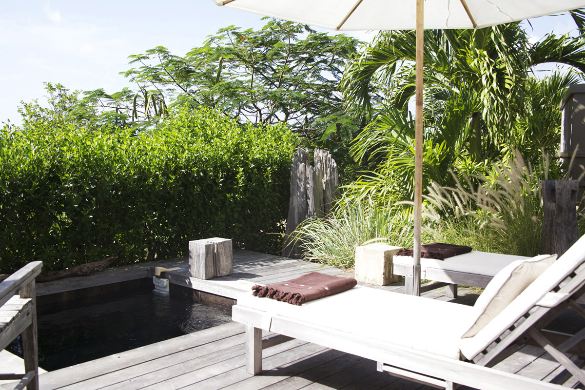 Shaded terrace with sun loungers and tropical greenery beside a plunge pool at a St Barts villa rental