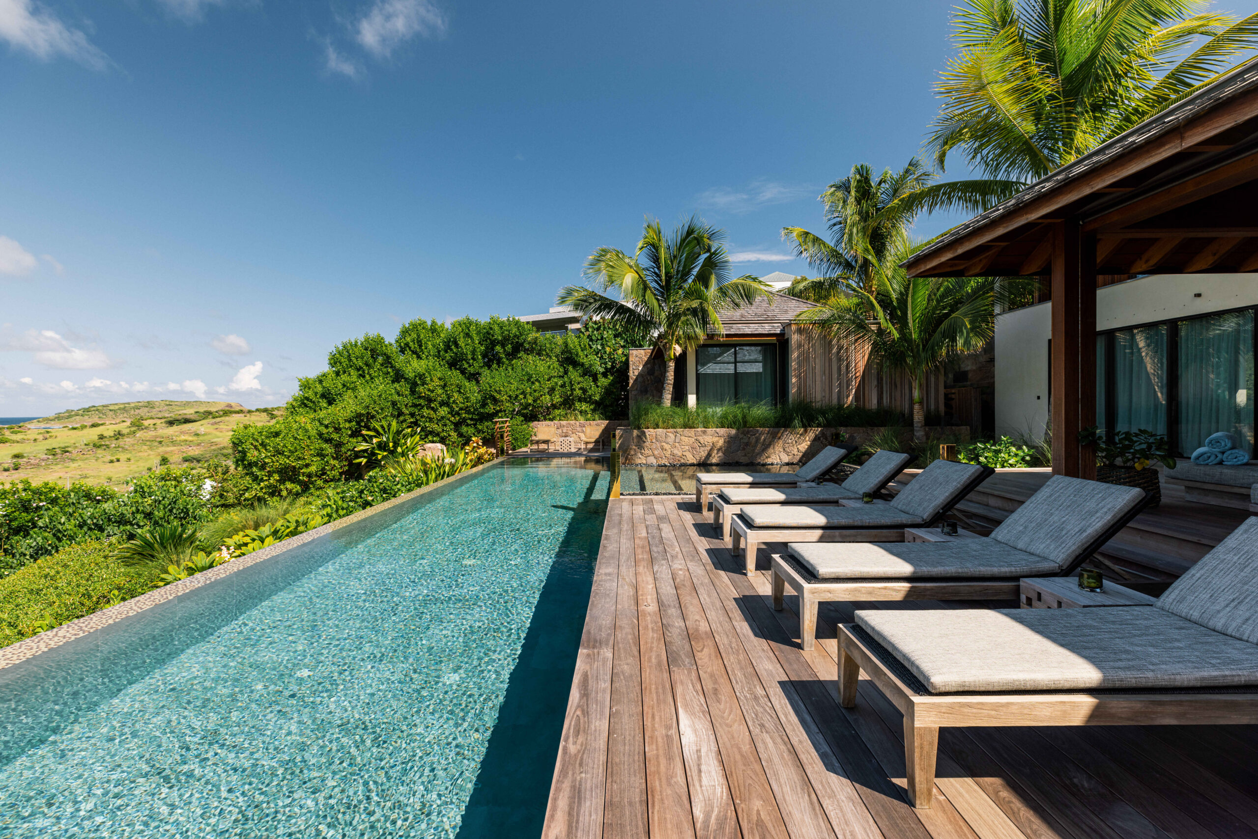 Poolside lounge area with comfortable seating overlooking a stunning natural view