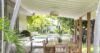 Shaded outdoor dining area with wooden table and garden views at a private St Barts villa