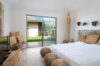 Bright villa bedroom in St Barts with natural textures, garden view, and serene design.