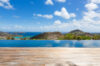 Infinity pool at a St Barts villa with panoramic ocean and hillside views from the wooden deck