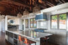 Modern kitchen in a St Barts villa with marble island, sleek cabinetry, designer lighting, and exposed wooden beams.