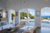 Bright living room in a St Barts villa opening onto a pool terrace with sun loungers and panoramic Caribbean views.