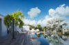 Poolside deck with palm trees and sun loungers at luxury villa rental in St Barts