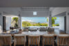 Spacious dining area in a St Barts villa opening to a lounge terrace with panoramic hillside views