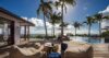 Palm-lined pool terrace at a luxury St Barts villa with lounge seating and panoramic ocean views