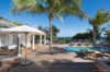 Luxury villa in St Barts with a serene heated pool framed by palm trees and sweeping Caribbean views.