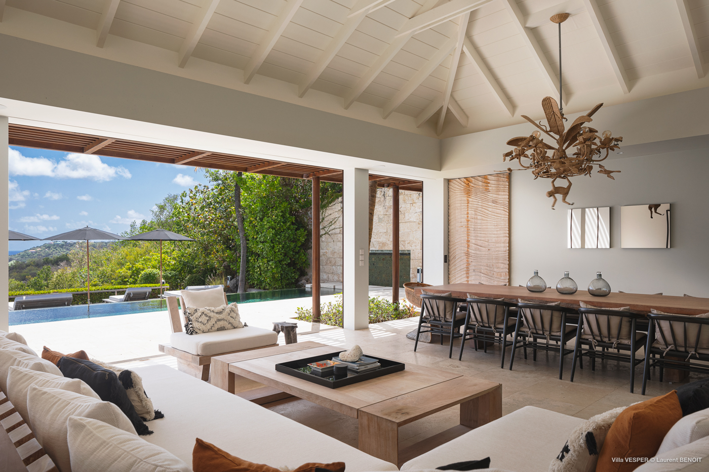 Open-air living and dining room in luxury St Barts villa with pool and hillside views