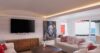 Contemporary living room in St Barts villa with modern artwork, flat-screen TV, and pool view