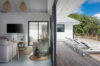 Seamless indoor-outdoor living with modern lounge opening to a poolside deck with sun loungers in a St Barts villa rental.