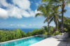 Infinity pool at a St Barts villa with palm trees, sun loungers, and panoramic views of the Caribbean Sea.
