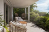 Shaded terrace lounge at St Barts villa with cushioned chairs surrounded by tropical greenery