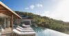 Infinity pool at a St Barts villa with sun loungers on the terrace and hillside views under bright skies.