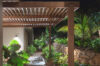 Garden pathway at a St Barts villa with wooden pergola, stone walls, and tropical plants illuminated at night