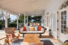 Charming covered veranda with antique-style seating and colorful cushions in St Barts villa rental.